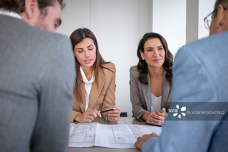 在会议中与同事讨论计划的漂亮女商人图片素材