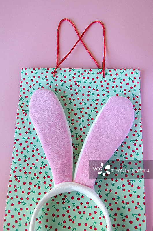 粉色背景上的兔子耳朵和购物袋图片素材