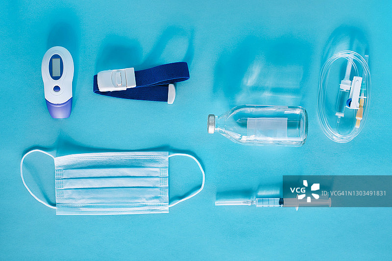 包含电子温度计、防护口罩、止血带、输液系统、生理盐水瓶和注射器的新冠病毒防护套装图片素材