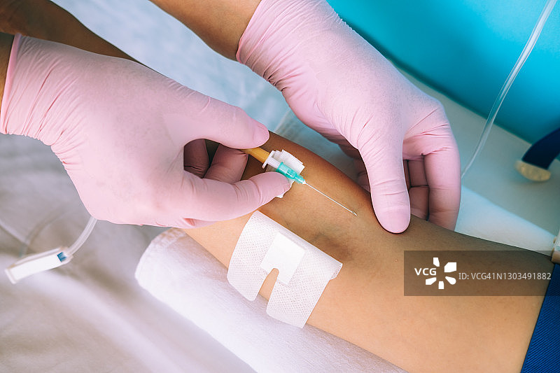 医生双手戴粉色手套 准备输液针剂图片素材