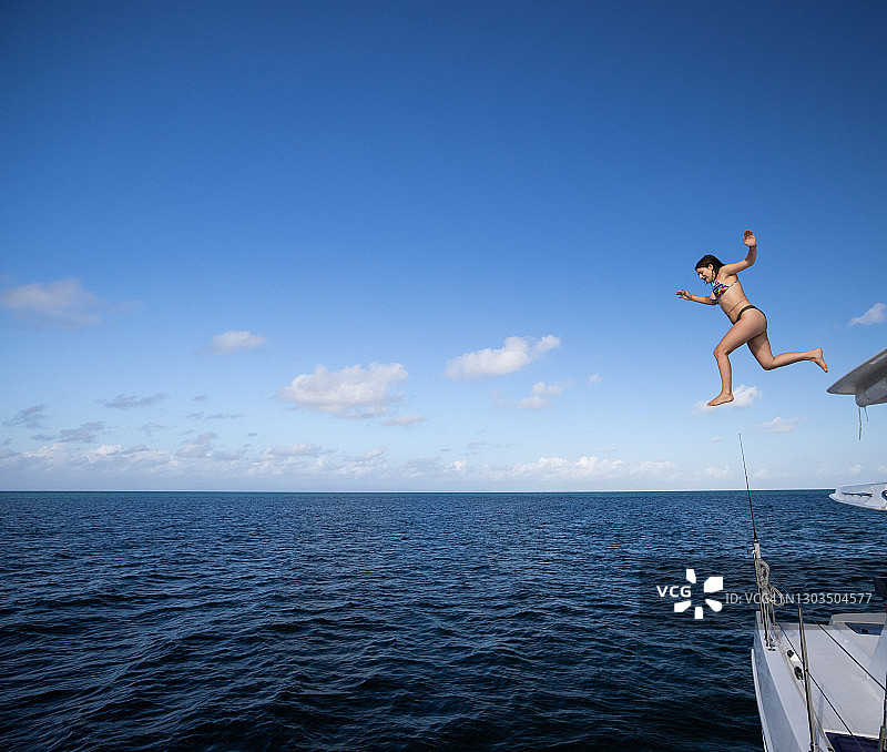 年轻女人从船上跳入大海图片素材
