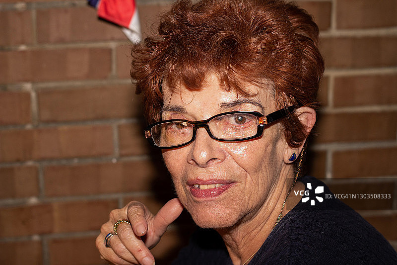 一位戴着老花镜的中年妇女转身看着镜头图片素材