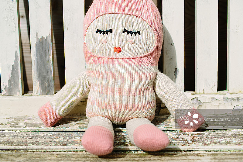 毛绒玩具娃娃在木凳上放松图片素材