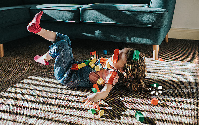 彩色木块散落时向后摔倒嬉戏的小女孩图片素材