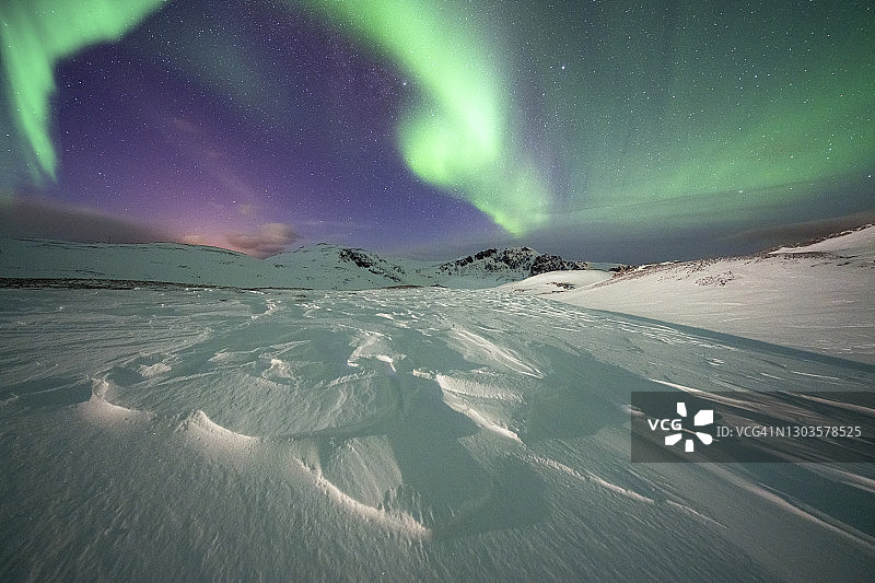 北极夜空中的绿色北极光，位于挪威图片素材