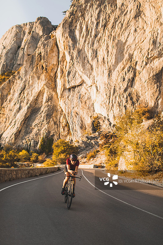 在山区骑公路自行车的专注女性图片素材