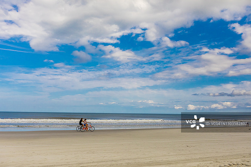 疫情期间杰克逊维尔海滩重新开放后，情侣骑自行车（美国佛罗里达州）图片素材
