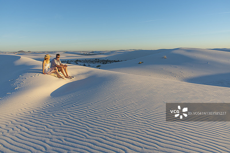 日落时分，一对情侣在美国新墨西哥州白沙国家公园游玩图片素材