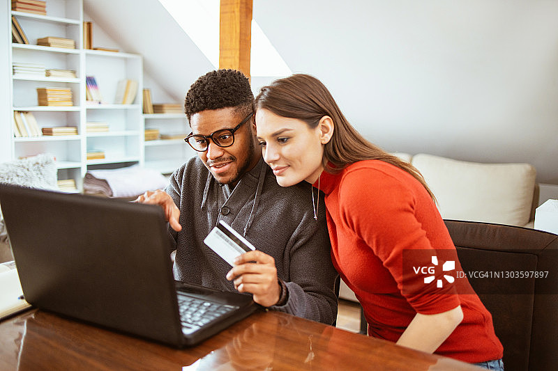 在家用信用卡在网上购物的多种族情侣图片素材