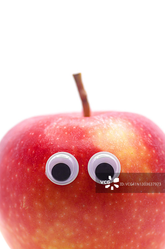 白色背景上带有卡通眼睛的红苹果，含留白图片素材