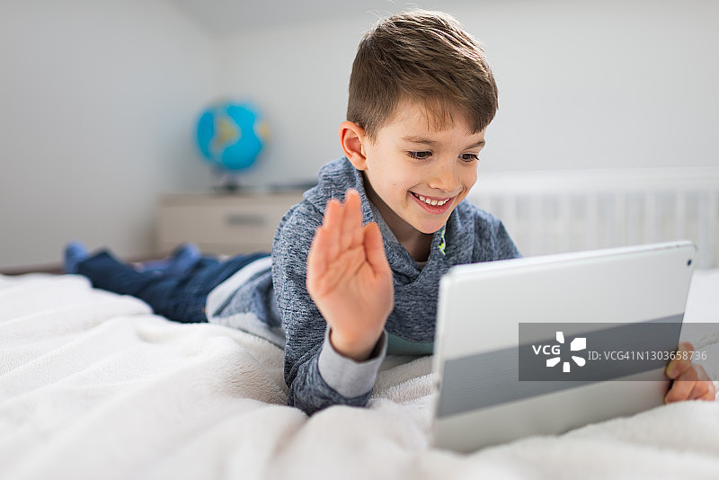 使用平板电脑的可爱男孩图片素材