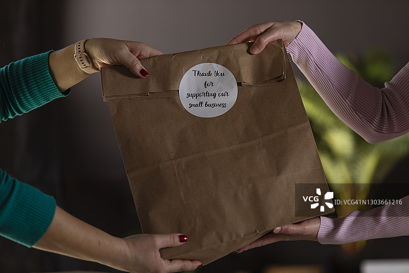 女商人向忠实客户赠送关怀包图片素材