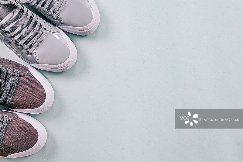 两双灰色运动鞋，灰色背景，特写俯视图图片素材