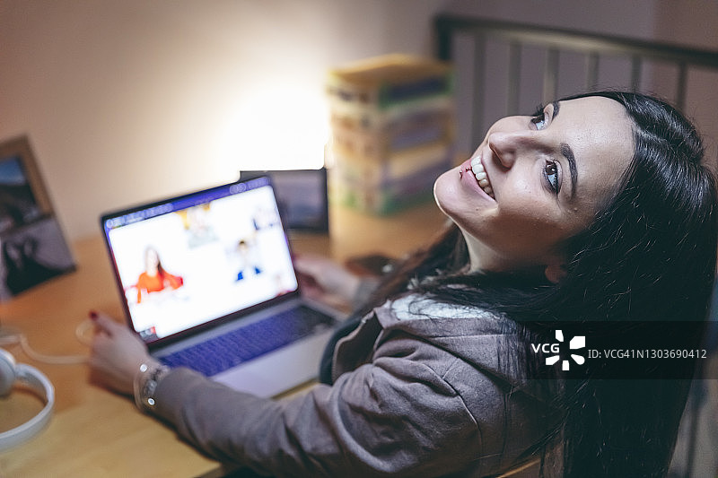 年轻女人在视频会议中微笑地看向光亮处图片素材