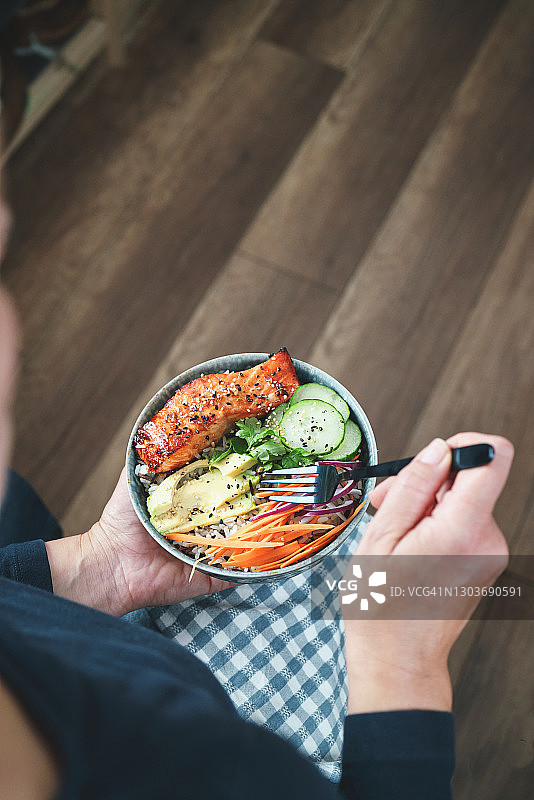 准备香辣三文鱼饭碗配米饭、胡萝卜、黄瓜和鳄梨图片素材