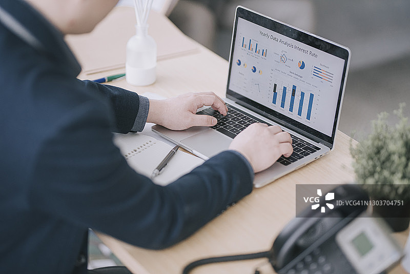 中国男子在办公室使用笔记本电脑工作图片素材