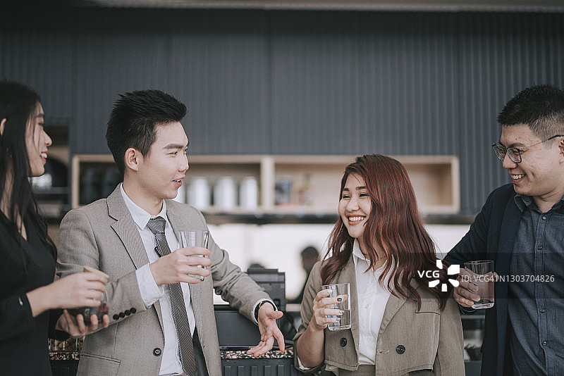 亚洲华裔商业同事在吧台前讨论图片素材