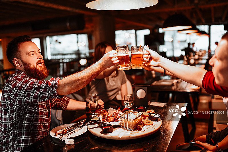 朋友们在餐厅晚餐时举杯庆祝图片素材