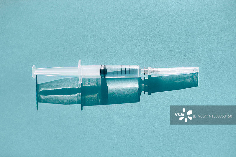 蓝色背景上的注射器与阴影图片素材