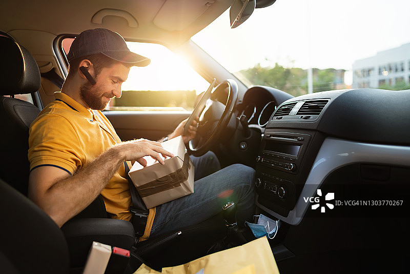 微笑的快递员正在查看下一个客户的地址图片素材