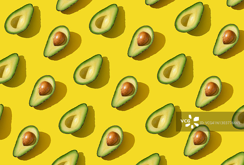 黄色背景下的牛油果半果图案图片素材