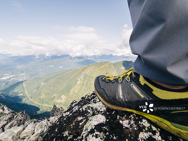 山顶俯瞰森林深谷的跑鞋视角图片素材
