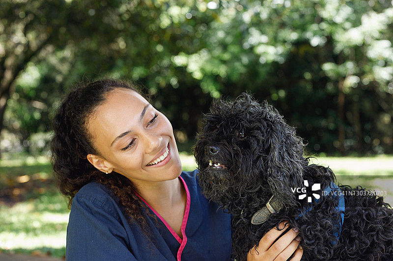 澳大利亚原住民兽医学生抚摸黑狗图片素材