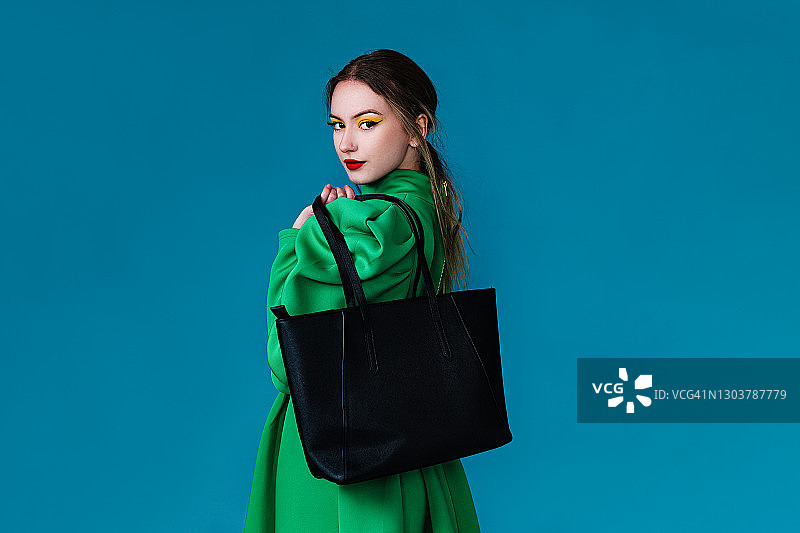 身穿绿裙手提包的美丽女人图片素材