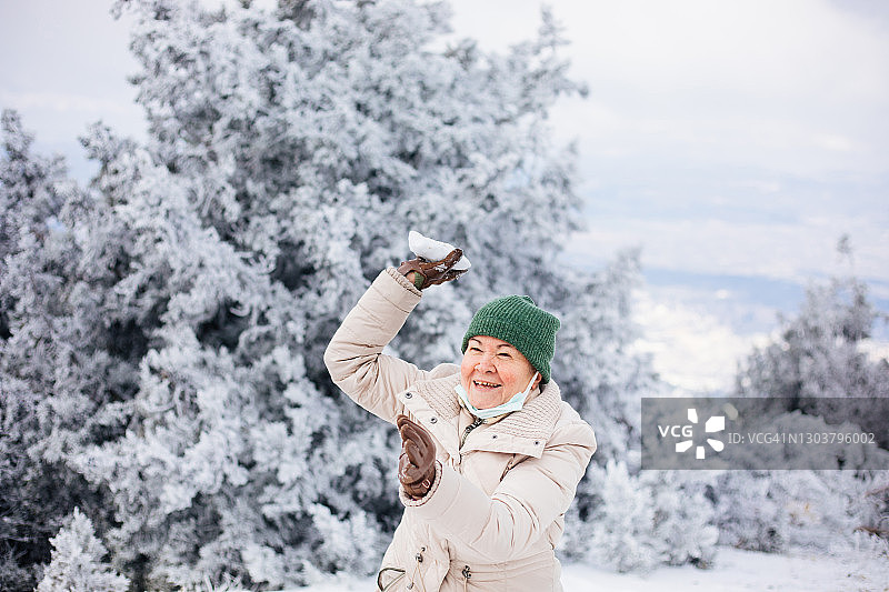 年长的女人在扔雪球图片素材