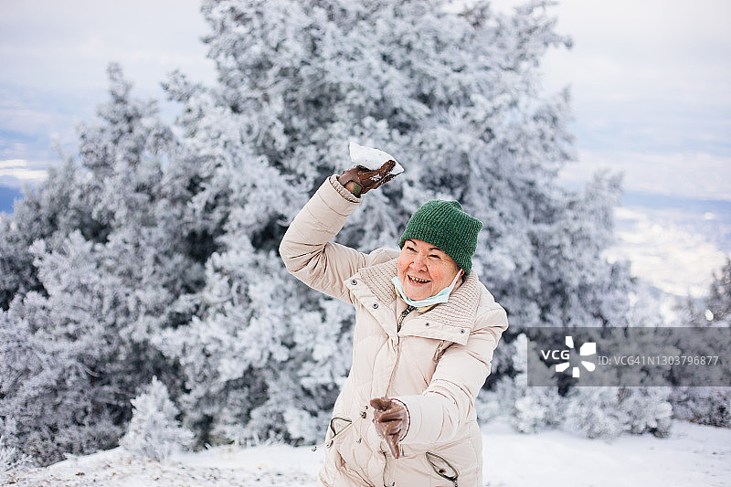 年长的女人在扔雪球图片素材