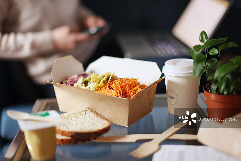 外卖食品特写，背景是工作的女性图片素材