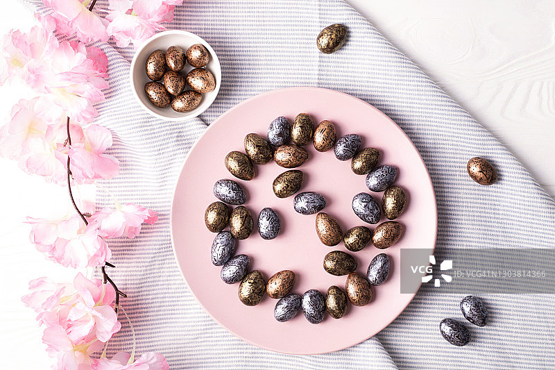 白色木质背景盘中的巧克力复活节彩蛋图片素材