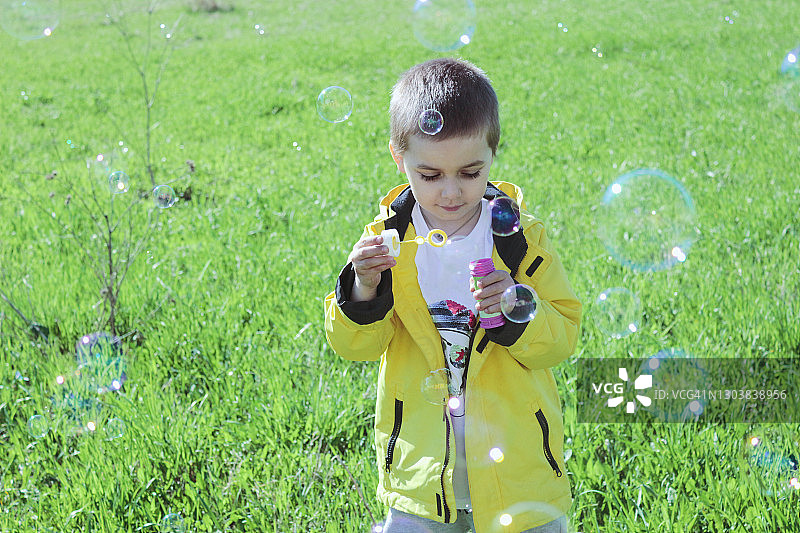可爱男孩在后院玩肥皂泡图片素材