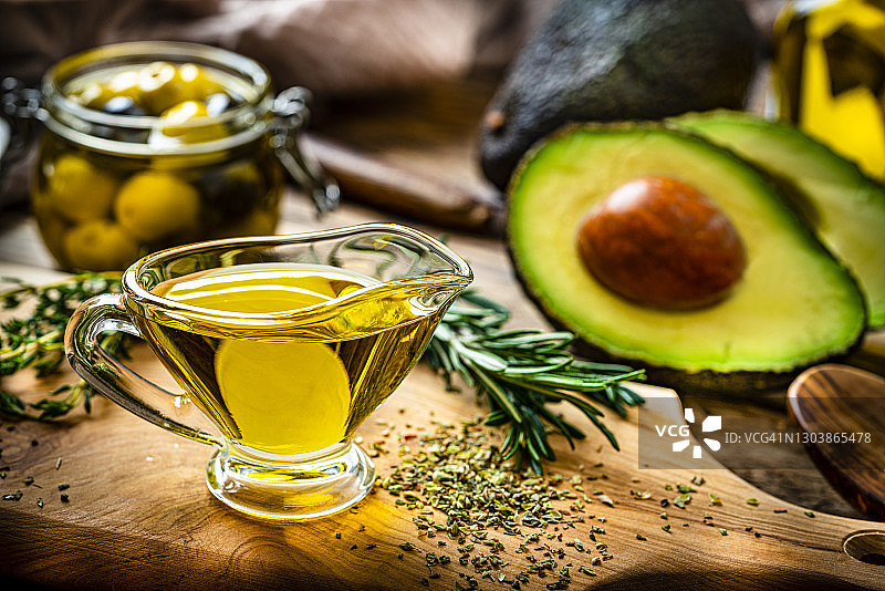 牛油果油和橄榄，置于乡村木桌上图片素材