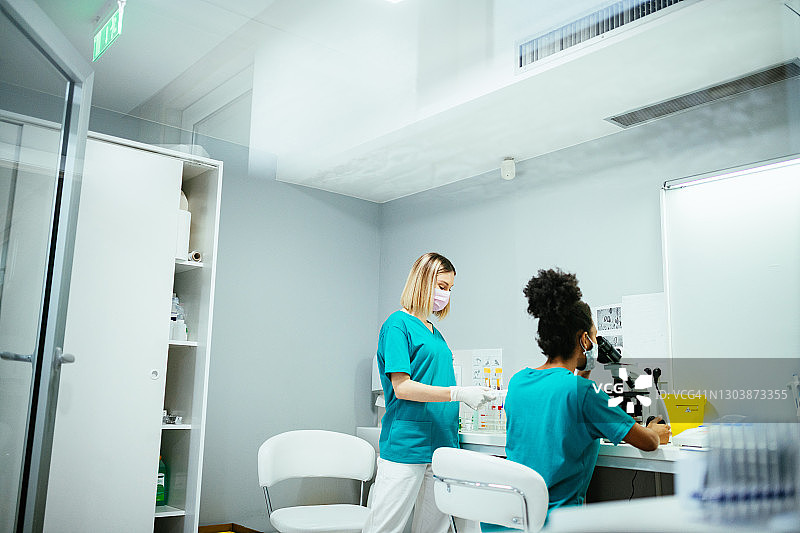 在冠状病毒大流行期间在实验室工作的女科学家，寻找对抗致命病毒的疫苗图片素材