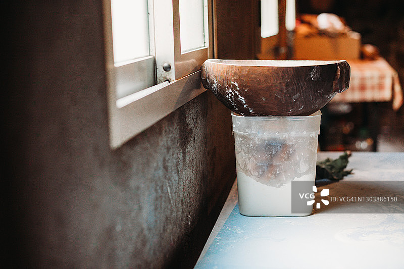 桌子上葡萄牙或加利西亚的木制面包盘，旁边是面粉盒图片素材