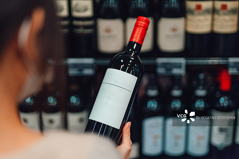 在酒类商店选择红酒的女人图片素材