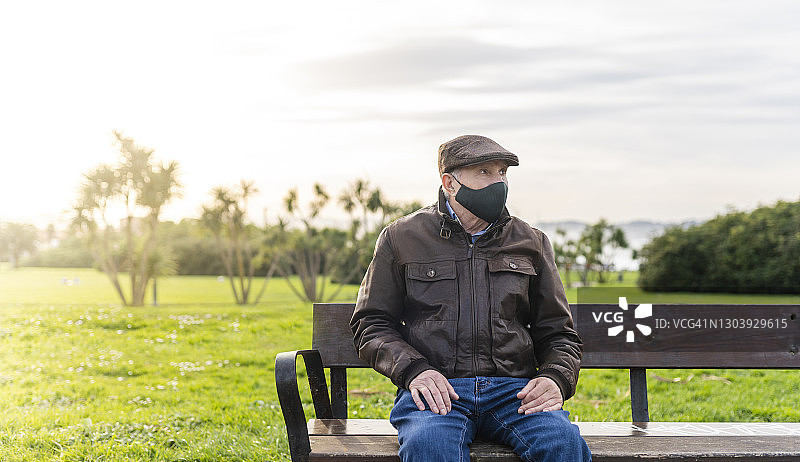戴口罩坐在长椅上的男人图片素材