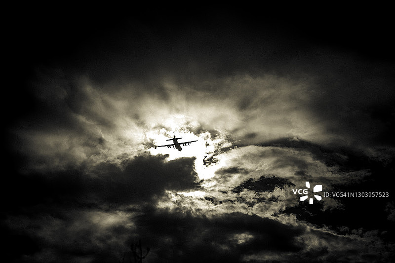 多云天气中飞机飞行的图像图片素材