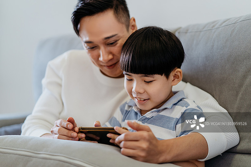 华人父子在家玩手机游戏图片素材