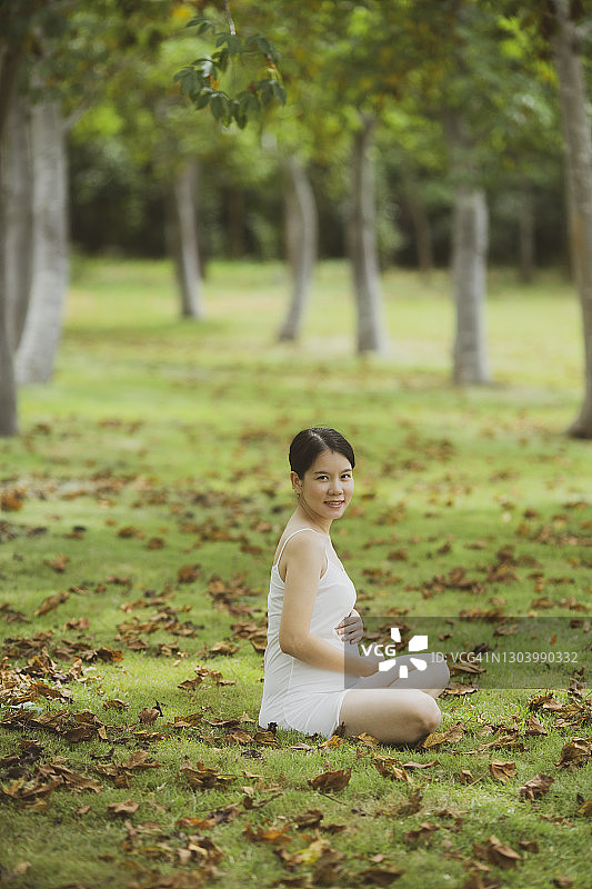 在花园树下放松的亚洲孕妇图片素材