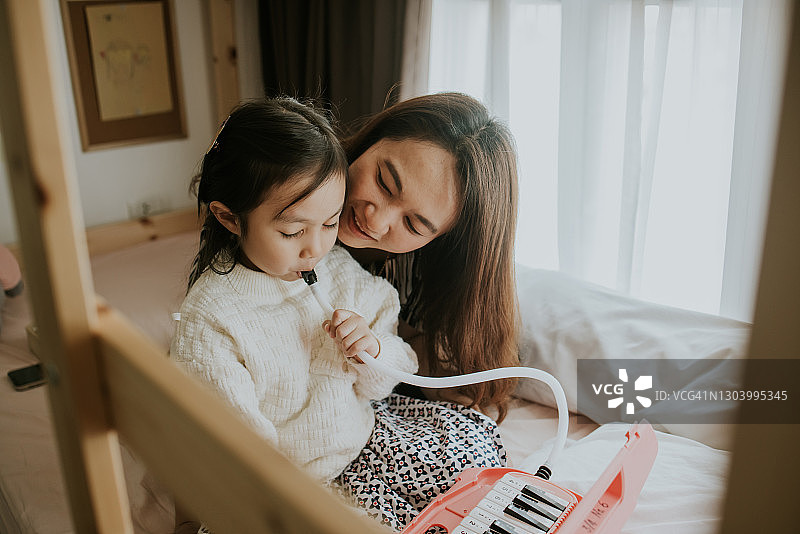 女儿演奏电子琴给妈妈听图片素材