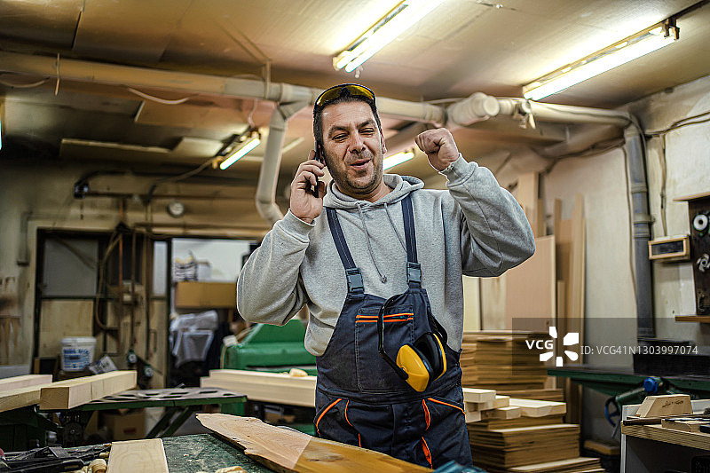 在车间使用手机的体力劳动者图片素材
