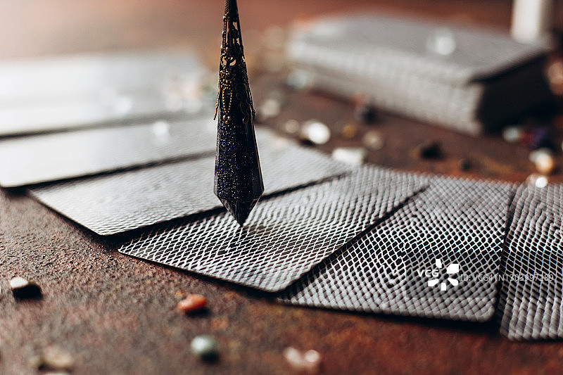 漂亮的深色摆锤在摊开的塔罗牌中选择图片素材