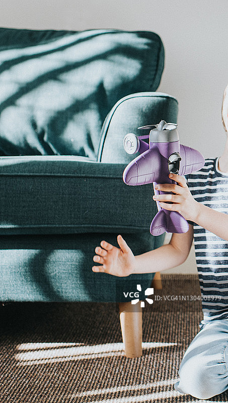 放紫色玩具飞机的小男孩图片素材