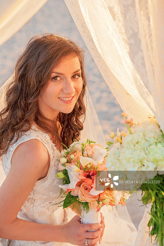 在海滩婚礼现场户外手捧花束的新娘图片素材