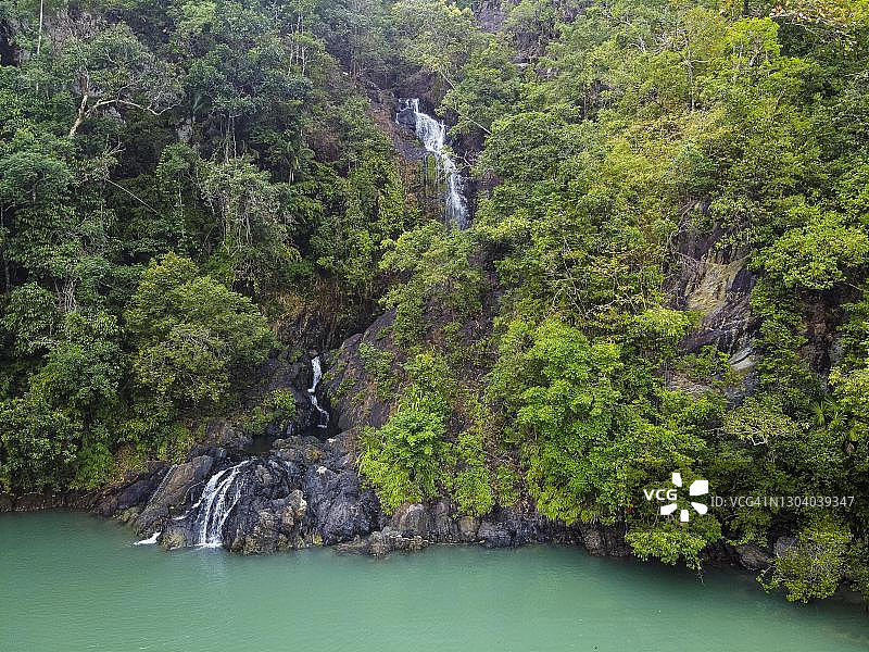 缅甸丹老群岛穹顶岛上的瀑布直接落入大海的航拍图片素材