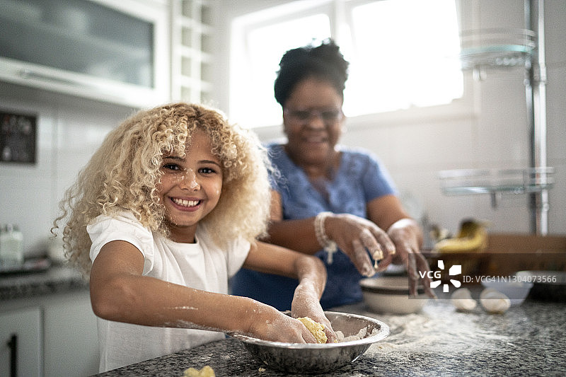 孙女和祖母在家烘焙的肖像图片素材