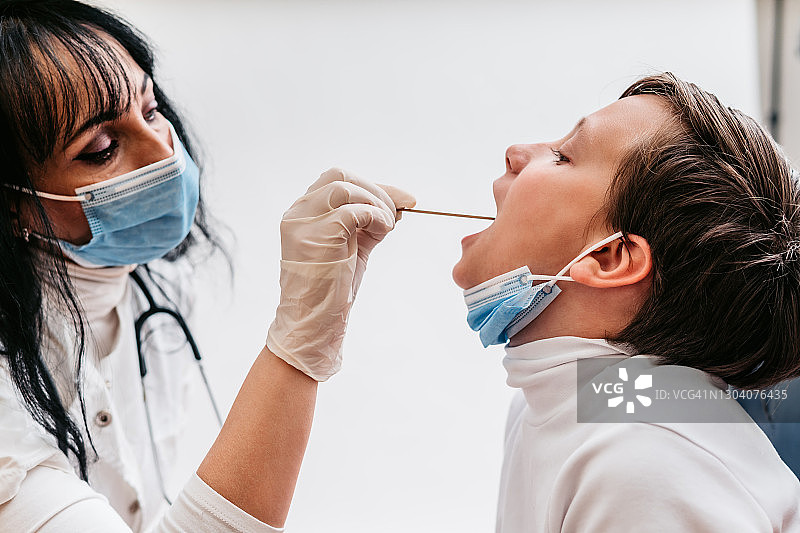 女医生正在给孩子做咽拭子测试图片素材