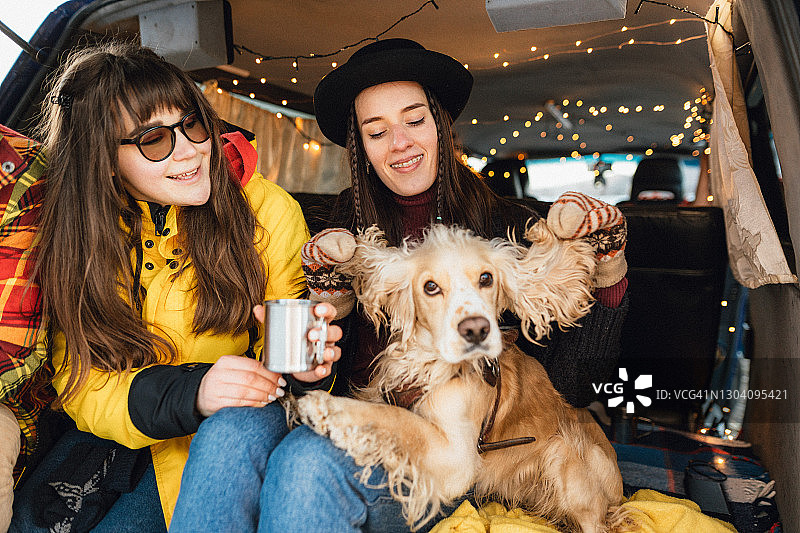 潮人朋友们在复古面包车里和狗玩耍图片素材